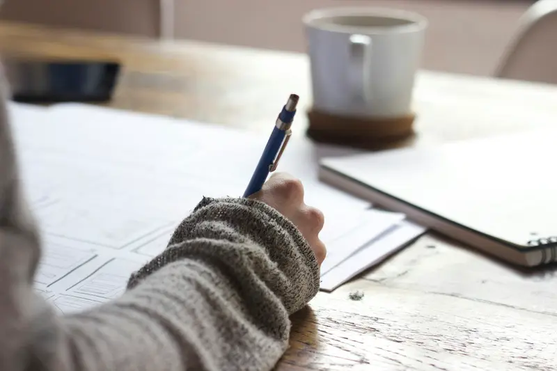 Aluno a escrever num caderno durante o estudo